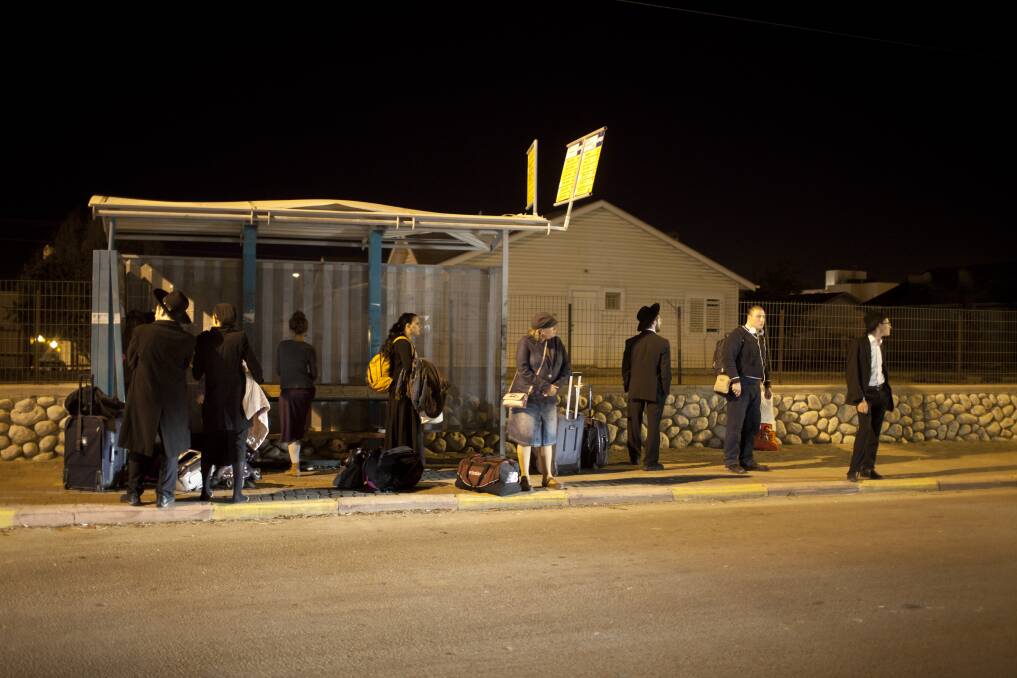 People wait for a bus to leave town on in Netivot, Israel. Photo by Uriel Sinai/Getty Images