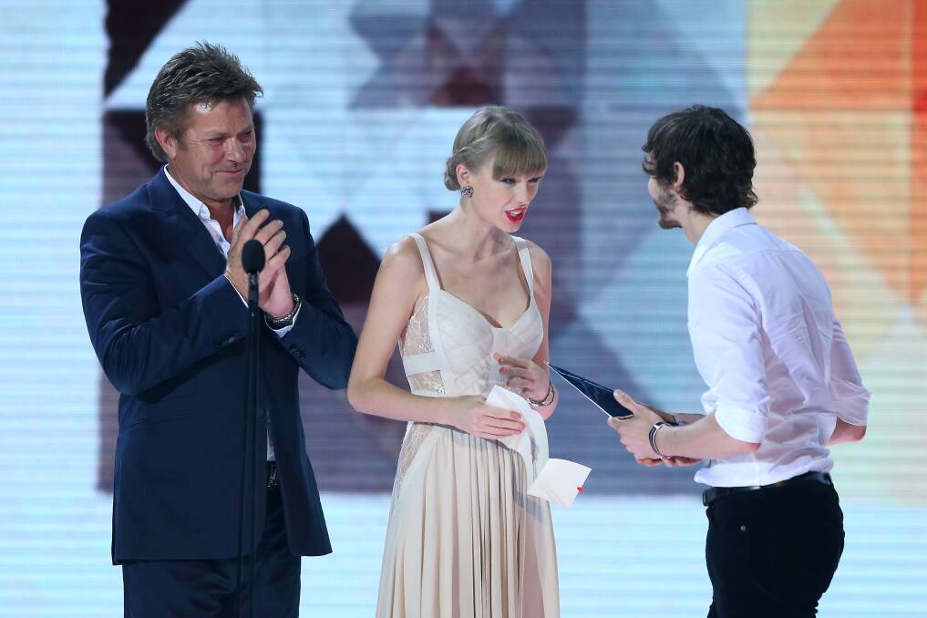 Richard Wilkins and Taylor Swift congratulate Wally DeBacker of Gotye on winning the ARIA for best male artist at the 26th Annual ARIA Awards 2012. Photo by Don Arnold/Getty Images