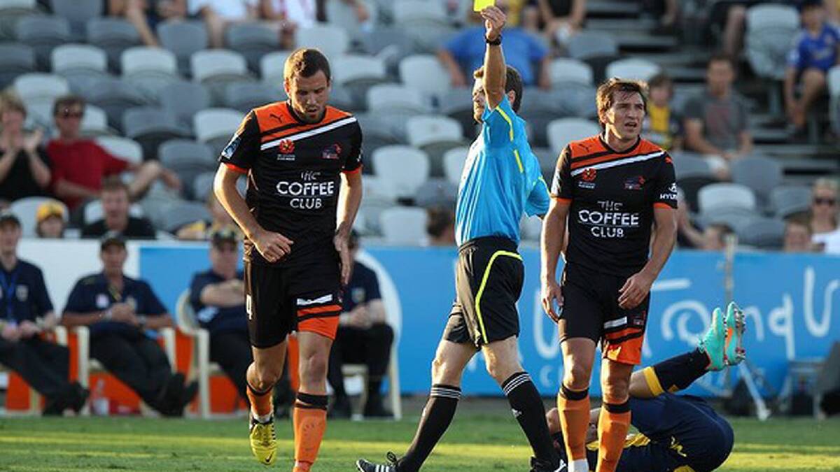 A yellow card is issued to number four Brisbane Roar player Mathew Jurman. Photo: Brendan Esposito