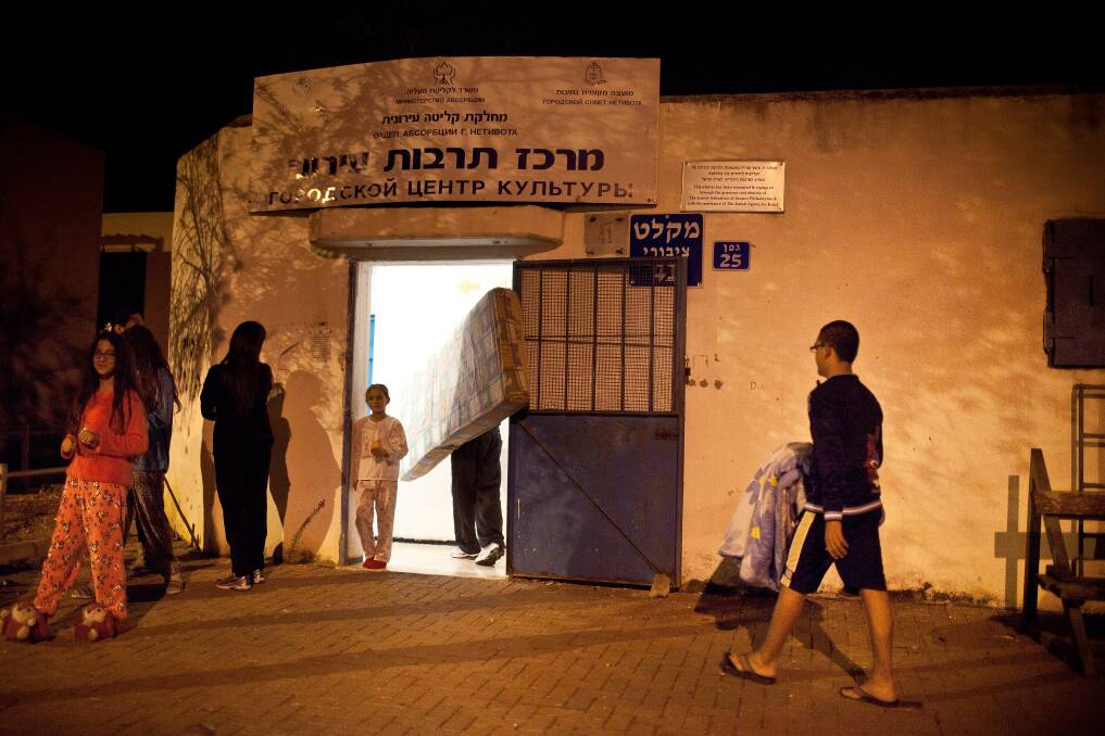 Israeli stand outside a bomb shelter in Netivot, Israel. Photo by Uriel Sinai/Getty Images