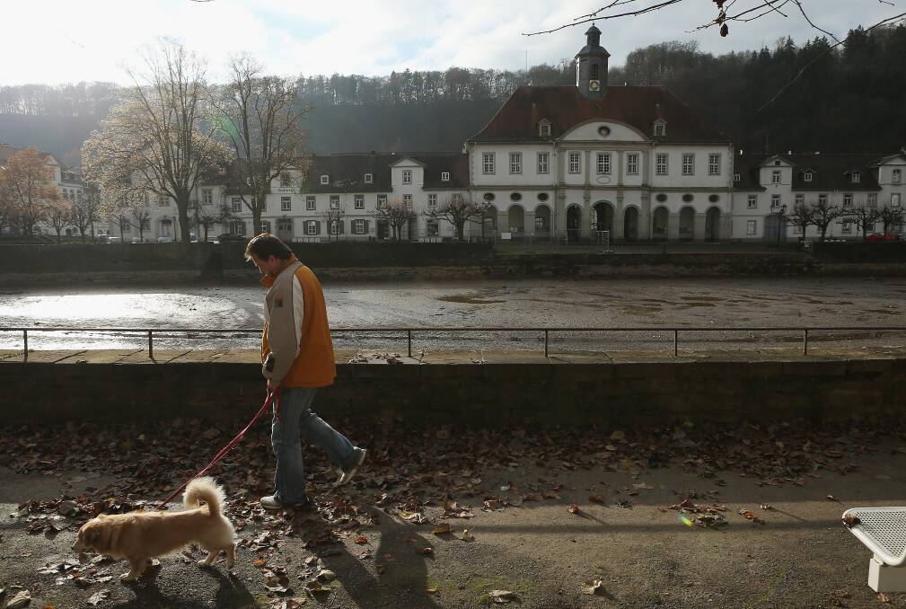 A man walks his dog past town hall in Bad Karlshafen, Germany. Photo by Sean Gallup/Getty Images