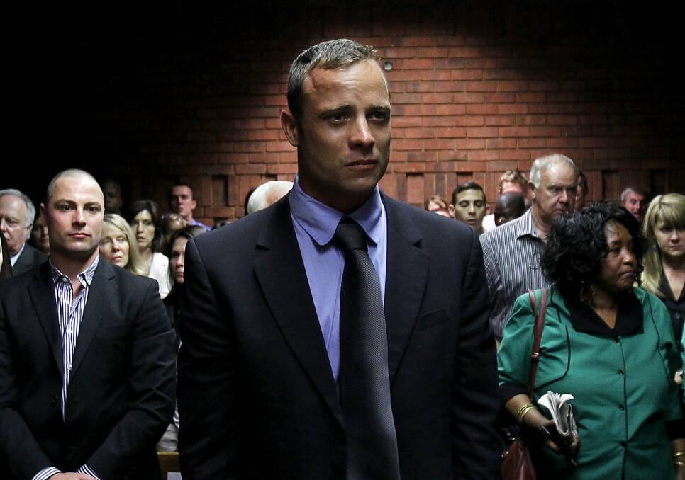 Oscar Pistorius awaits the start of court proceedings while his brother Carl looks on in the Pretoria Magistrates court February 19, 2013. Photo: REUTERS/Siphiwe Sibeko