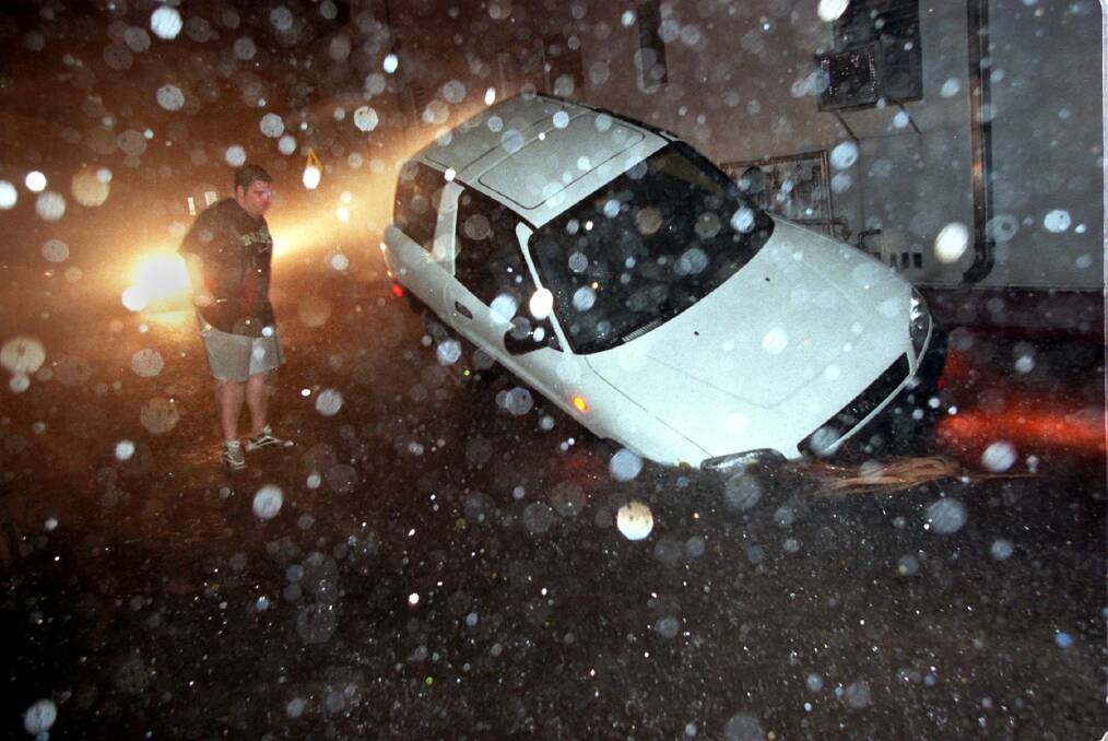 Tony Jenners watches as his car, an RAV 4, falls into a sinkhole Monday in South Miami Beach, Florida. Photo: Pat Farrell/Miami Herald/MCT